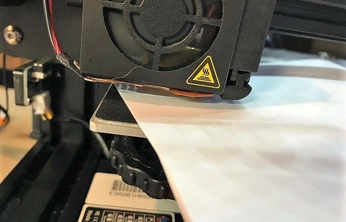Sliding the paper under the nozzle.