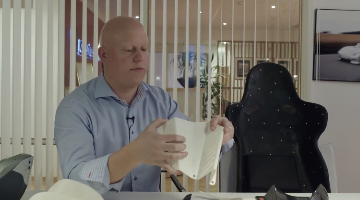 Koenigsegg's CEO holding a 3D printed prototype for the leg rest