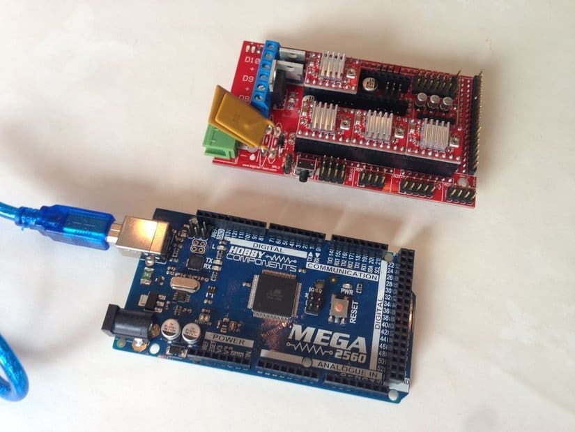 The RAMPS 1.4 board and the Arduino Mega. The blue USB cord goes to the PC.