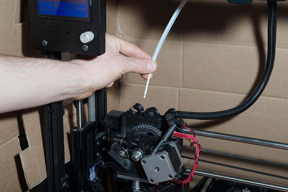Inserting the filament into the extruder by hand.