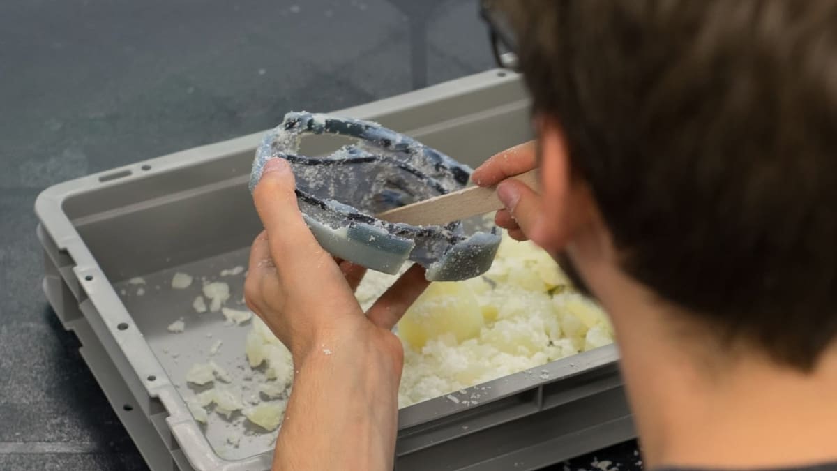 Manually removing the remaining support material.