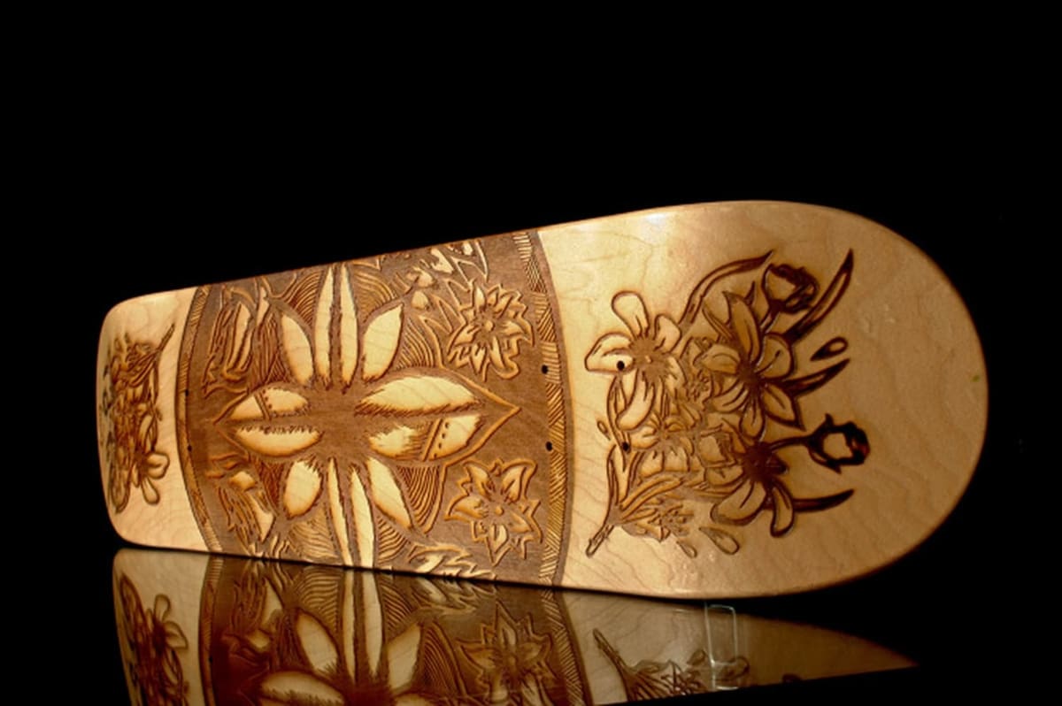 Laser-engraved design on a wood skateboard.