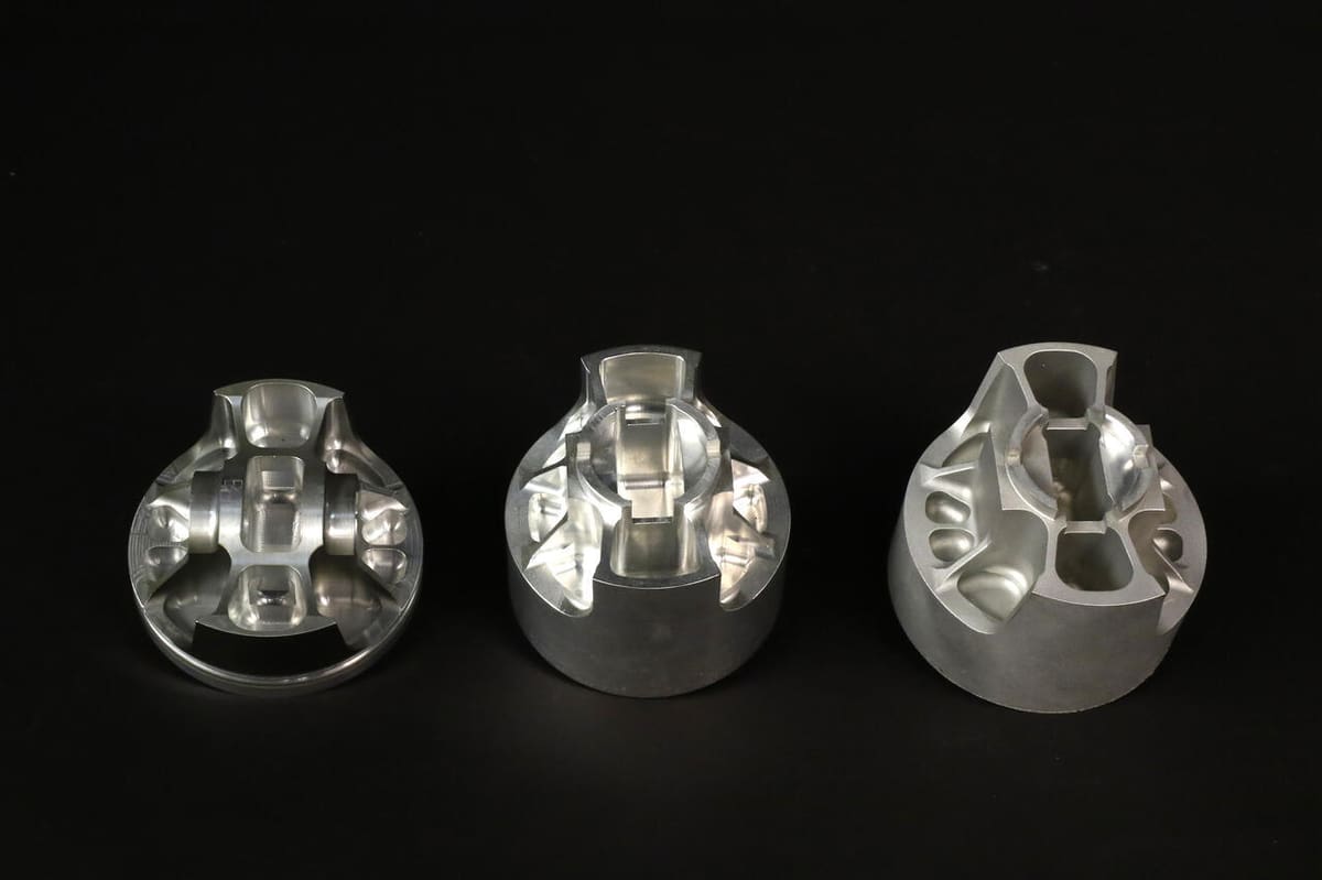 Bead-blasted billet piston (far right) on underside to eliminate stress risers in machining.