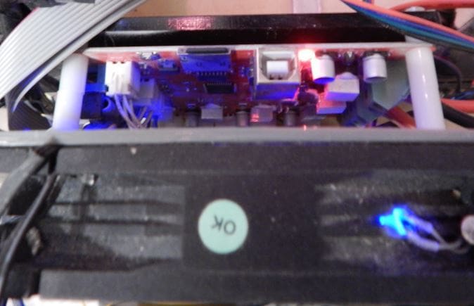 The control board of a printer, with a 120-mm fan (bottom) mounted for cooling.