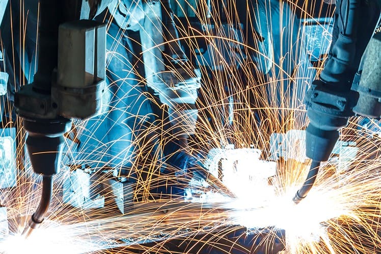 Machines like these appear in an FMS to weld parts.