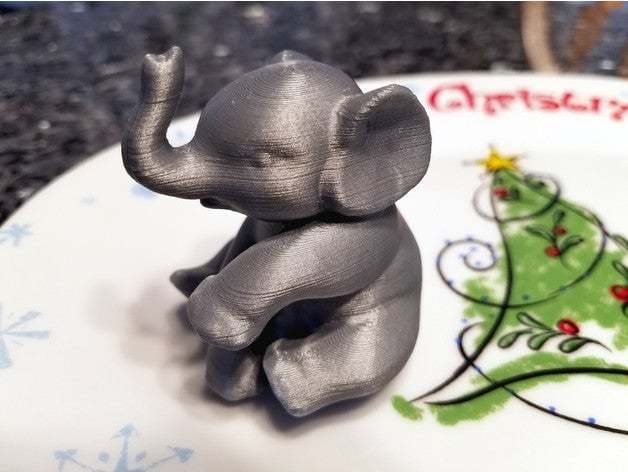 A sitting elephant in silky grey.