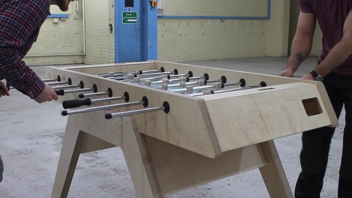 An epic foosball match being played on an epic table.
