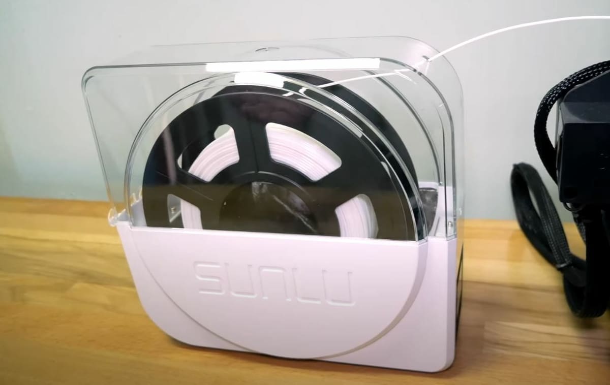 The FilaDryer S1 has filament-feeder hole so you can print with your filament in the drying box