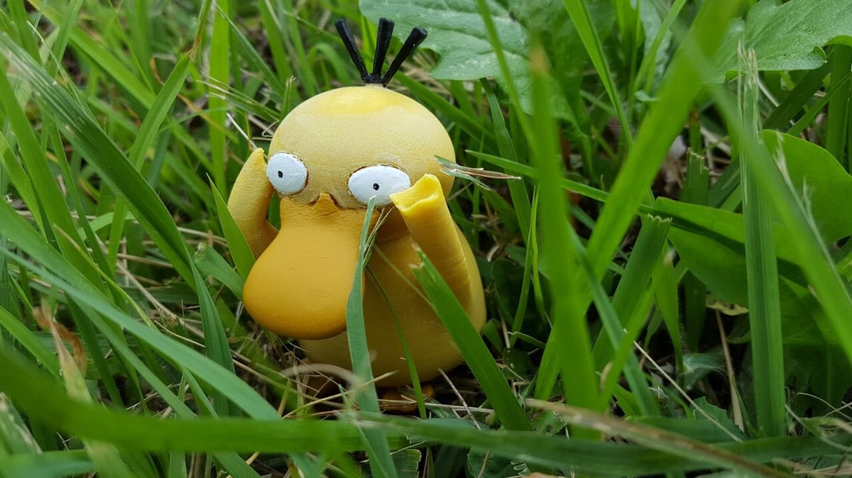 A nice painted Psyduck stands in the bush, trying to calm its headache