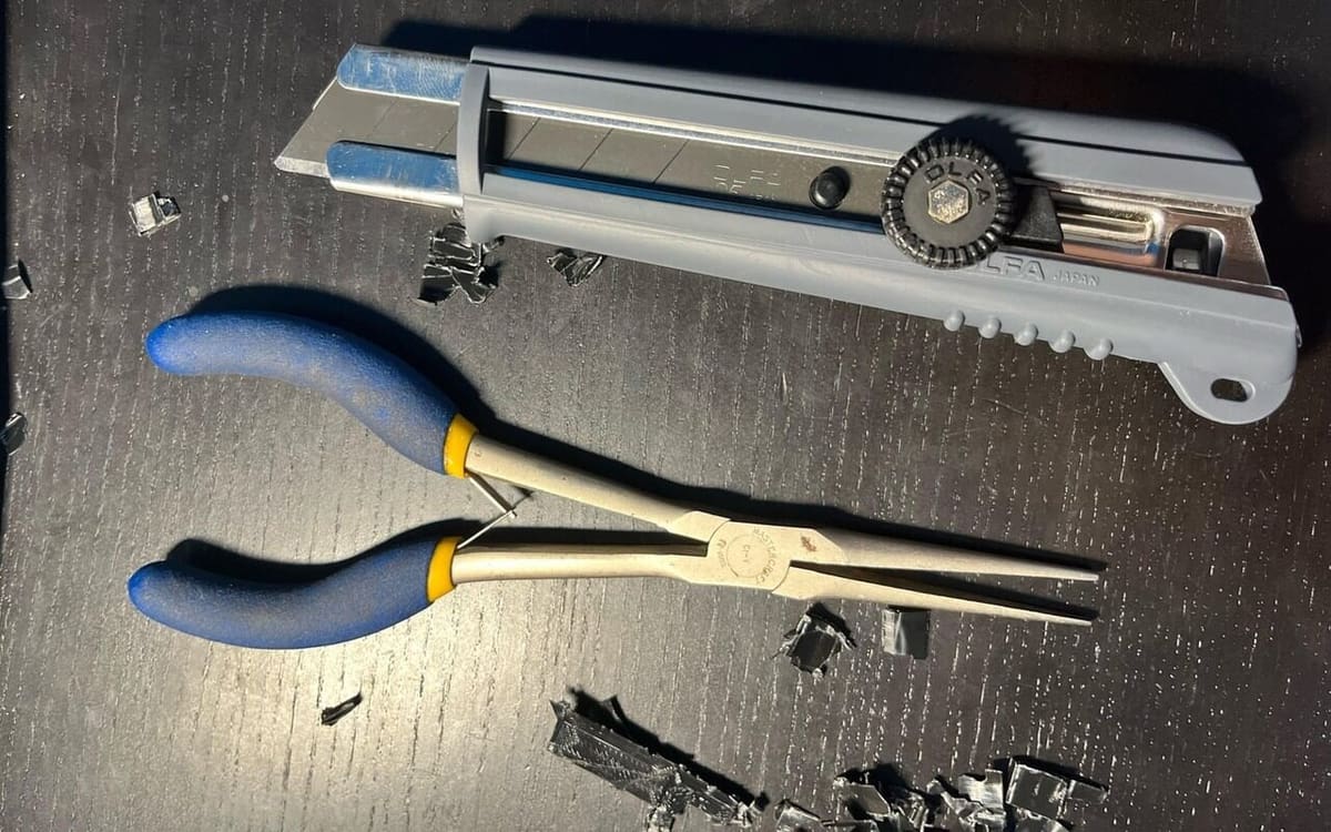 Long pliers or a flash cutter can reach where your fingers can't